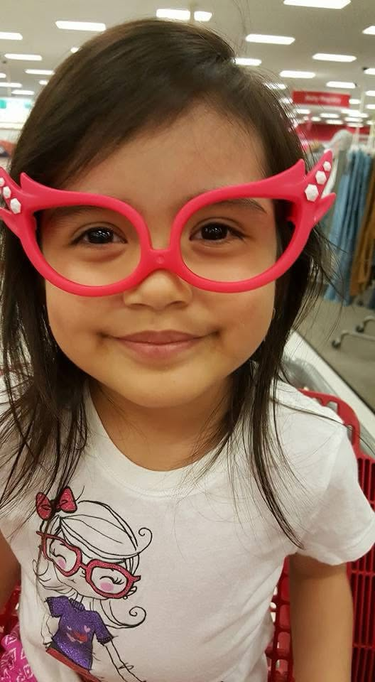 young Scarlette trying on oversized pink novelty glasses